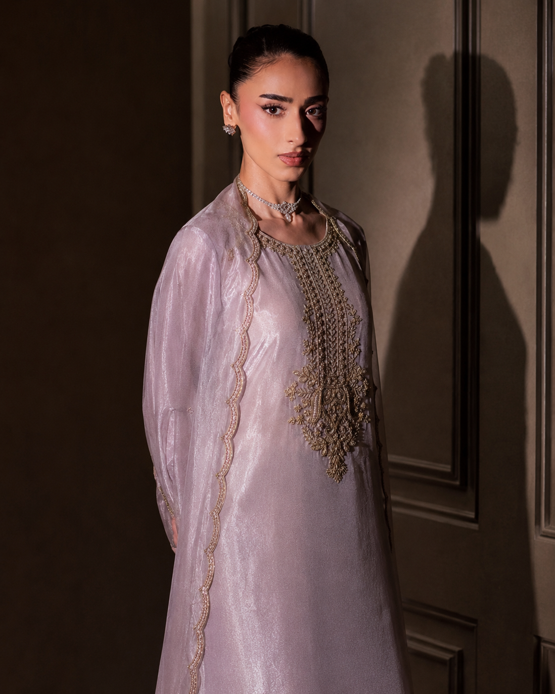 Meher lilac kurta set with gold zardozi placket — three-quarter editorial view against dark panelling