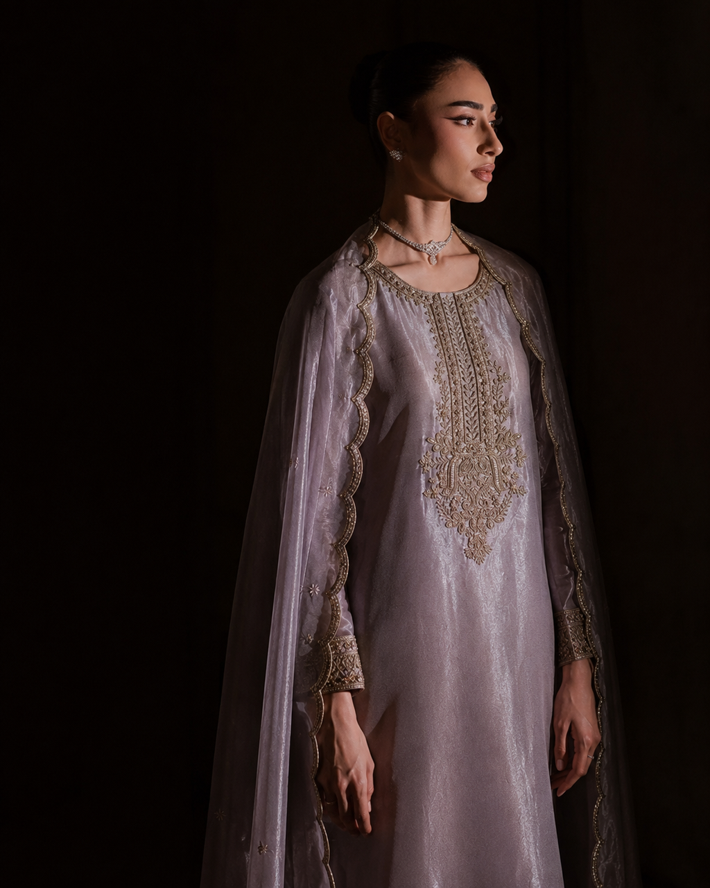 Meher lilac-mauve tissue silk kurta with hand-embroidered gold neckline and cuffs — side profile in low light