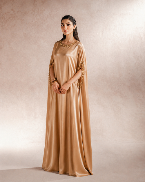 Aaira gold satin kaftan showing fluid drape and soft sheen, full length