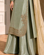 Detail of hand embroidered curved scalloped hem on sage green tissue silk kurta with matching sharara trousers
